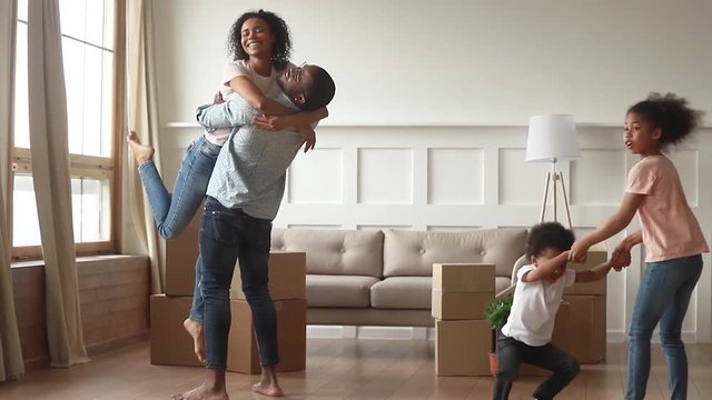 Happy overjoyed african family celebrate moving day relocation together