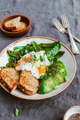 Fototapeta na wymiar Healthy breakfast or lunch. Fried snow peas, avocado, poached eggs are sprinkled chia seeds with toasts.