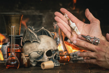 Alchemist or witch doctor or wizard is working at his magic table and producing a magic potion.