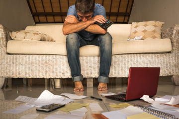 frustrated man at home living room couch doing domestic accounting overwhelmed and worried...