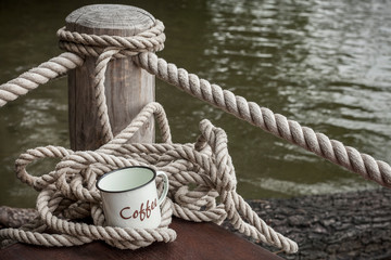 Fototapeta na wymiar Enamel Coffee Mug And Rope