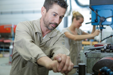 engineer inspecting finished steel roller in engineering factory