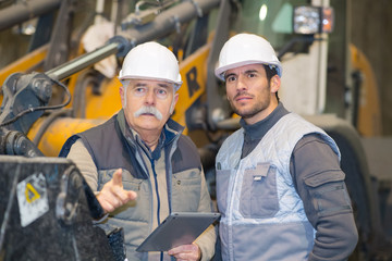 heavy equipment mechanics observing something