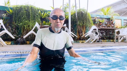 Old man standing in the swimming pool