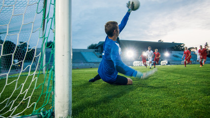 On Stadium Attacker Kicks the Ball and Scores the Goal, Soccer Goalkeeper Tries to Defend Goals Jumps and Catch the Ball. 