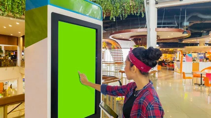 Deurstickers Woman touches a screen of self-ordering kiosk © Creativa Images