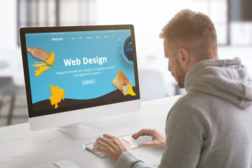 Guy work on modern web site on computer in graphic, web design studio office. Concept.