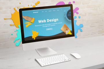Concept of web design studio with coimputer display and color drops on brick wall. Modern web design teme on screen. Concept of modern graphic studio desk. - obrazy, fototapety, plakaty