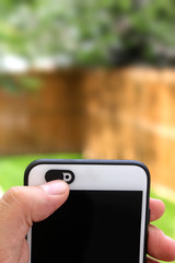 Person holding a mobile phone, sliding a selfie privacy camera cover