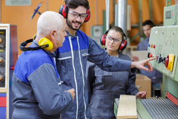 students with senior teacher by woodworking machine
