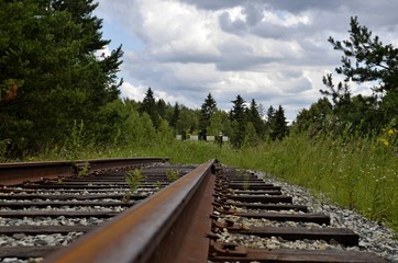 Old abandoned railway overgrown with grass. Close up railroad tracks and levers for changing railway lines. Railway impasse. The end of the railway track.