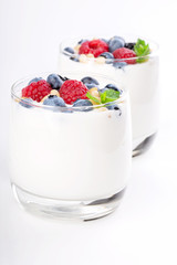 Two glasses of white yogurt with wild berries