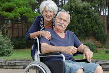 portrait of senior couple outdoors man in wheelchair