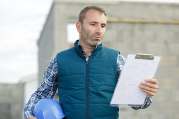 construction manager checking report at construction site