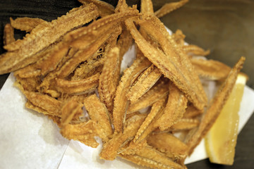 deep fried fish bone served with lemon and salt, a crispy appetizer in Izakaya (Japanese Bar)