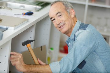 Naklejka na ściany i meble senior man carpenter at home