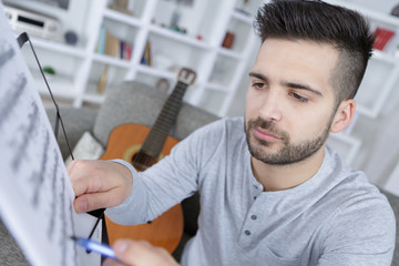 man practicing in playing acoustic guitar