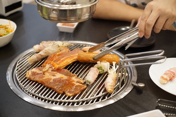 Close-up A man grilled chicken with vegetables on plate.