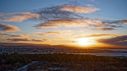 Obraz premium Beautiful sunset over East Reykjavik city in winter with view from top of perlan tower