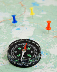 Black compass on map with colorful push pins © Valerii Evlakhov