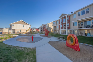 Playground in the middle of residential buildings under blue sky on a sunny day