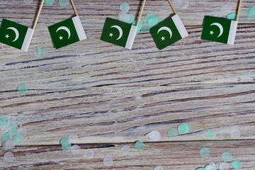 independence day of Pakistan. August 14. the concept of freedom, independence and patriotism. mini flags with confetti on wooden background. horizontal