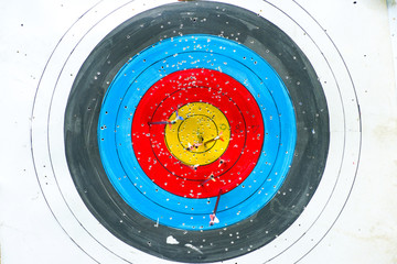Selective focus on archery colorful target with blurred group of arrows in foreground
