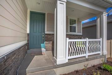 Green front door and porch with furniture at the facade of a home