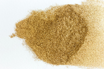 Golden glitter sparkle texture on white background.