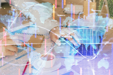 Obraz premium Double exposure of businessman working on laptop on background. International business hologram in front. Concept of success.
