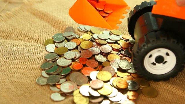 Toy backhoe  with pile of coin, in studio Chiangmai Thailand