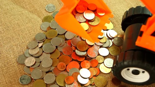 Toy backhoe  with pile of coin, in studio Chiangmai Thailand