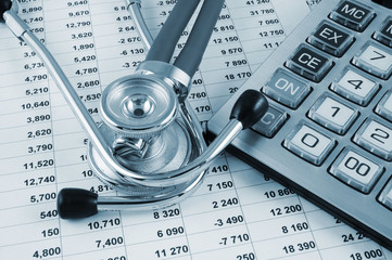 Stethoscope and calculator on document with digits