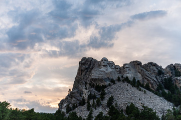 A dramatically colorful sky developing around sunset behind the four US presidents of Mount Rushmore, in North Dakota.