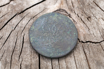 Obraz na płótnie Canvas The old copper coin of the Russian Empire in 1757, the era of the reign of Elizabeth Petrovna. Against the background of cracked wood. 
