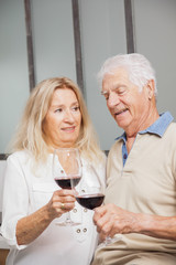 COUPLE SENIOR BUVANT DU VIN ROUGE
