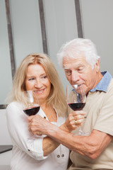 COUPLE SENIOR BUVANT DU VIN ROUGE