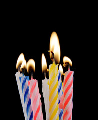 Burning birthday candles on black background