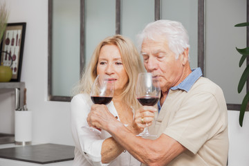 COUPLE SENIOR BUVANT DU VIN ROUGE