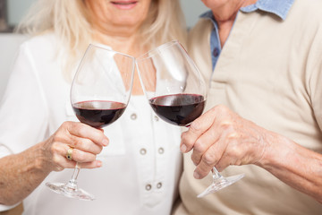 COUPLE SENIOR BUVANT DU VIN ROUGE