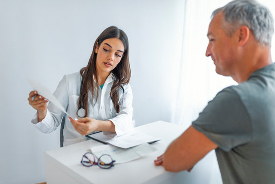 Doctor talking to her male patient at office. Female doctor giving a consultation to a patient and explaining medical informations and diagnosis. Doctor and patient in office talking.