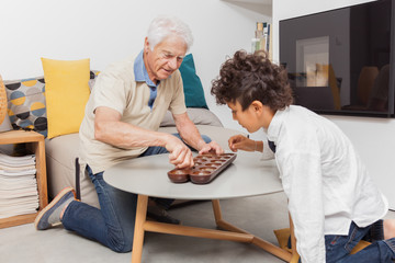 GRAND PERE JOUANT DE L'AWALÉ AVEC SON PETIT FILS