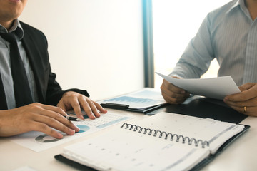 Two business partnership coworkers analysis strategy and gesturing with discussing a financial planning graph and company budget during a budget meeting in office room.