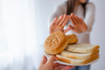 Gluten intolerance concept. Young girl refuses to eat white bread. Celiac Disease. No bread,...