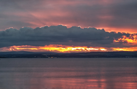 A beautiful landscape picture of a sunset over the Firth of Forth near Edinburgh in Scotland, United Kingdom 
