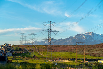Power lines towering over neighborhood and roads in the valley on a sunny day