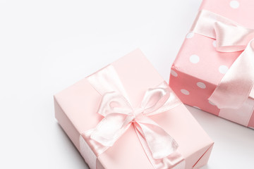 Gift box wrapped in pastel  paper with pink ribbon isolated on white background