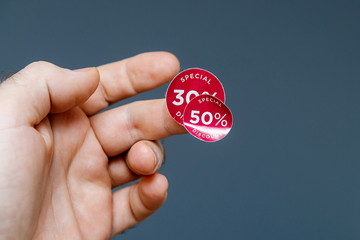 Man hand with glue sticked discount sale special price 30 than 50 percent red tags to be glued on...