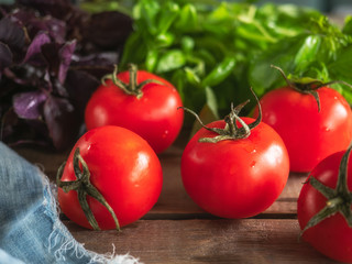 Ripe red tomatoes and fresh lettuce of different varieties lie on the Board table