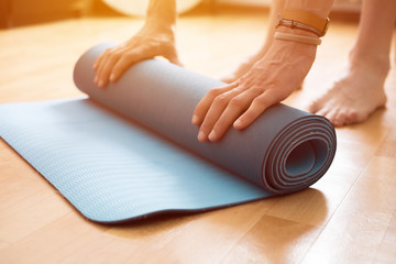 The concept of yoga and fitness mat in the hands.